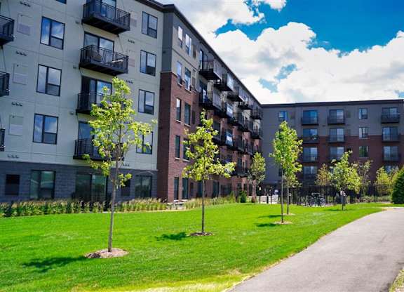 Apartment buildings with green lawns in front at The Bessemer at Seward Commons Apartments, Minnesota, 55404