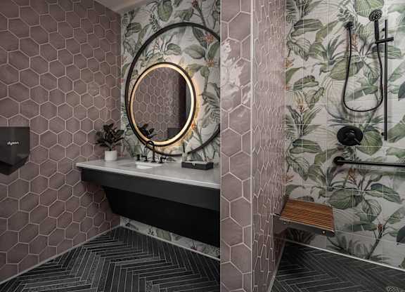 A bathroom with a hexagonal tile wall and a round mirror.