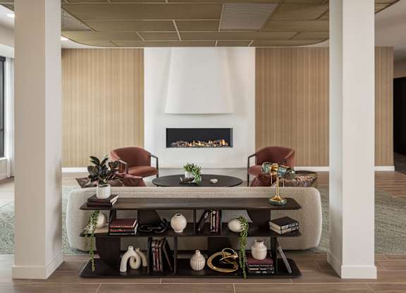 A living room with a fireplace and two chairs.