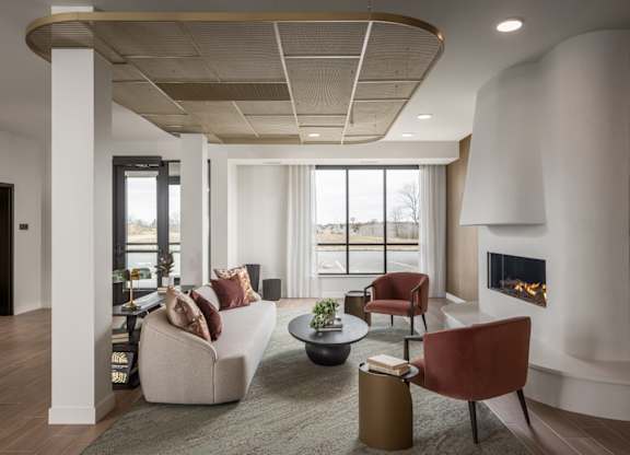 A modern living room with a fireplace and a large window.