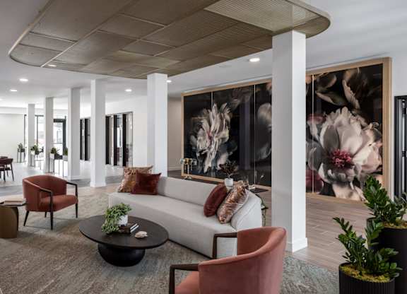 A modern living room with a large painting on the wall.