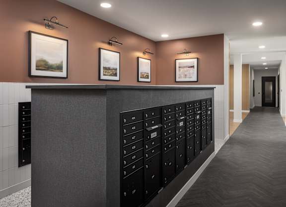 A hallway with a row of mailboxes on the wall.