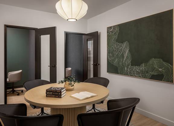 A conference room with a round table surrounded by chairs.