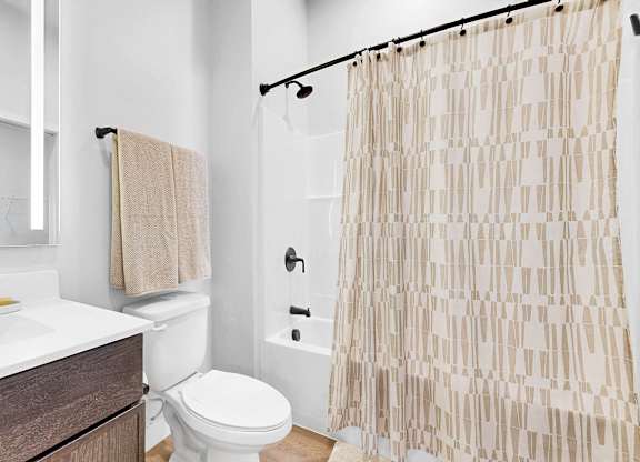 A bathroom with a toilet, sink, and shower curtain.