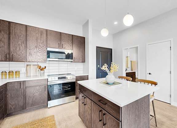 A modern kitchen with a white island and wooden cabinets.