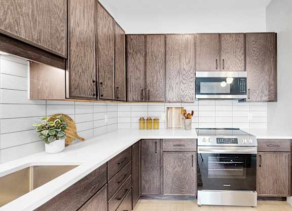 A modern kitchen with wooden cabinets and stainless steel appliances.