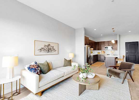 A living room with a white couch, a coffee table, and a painting on the wall.