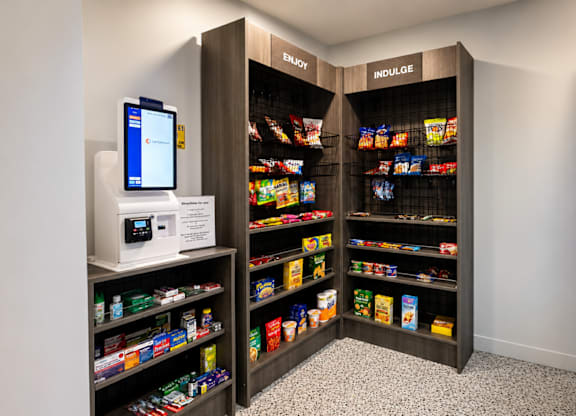 A modern vending machine is located in a room with a black and white checkered floor.