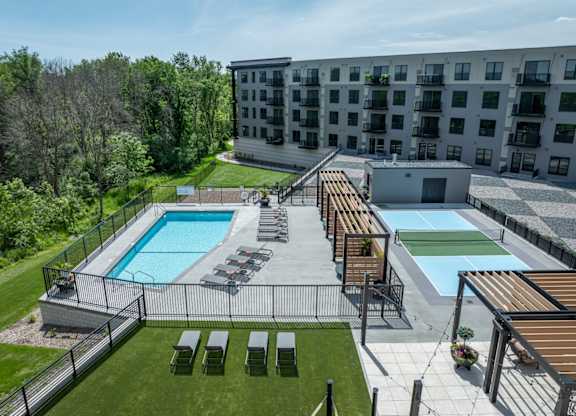 A large outdoor pool area with sun loungers and a wooden deck.