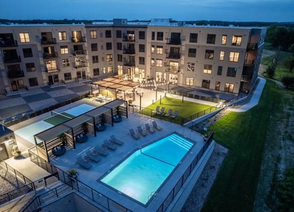 A large apartment complex with a pool and lounge area.