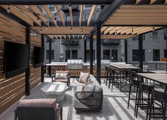 A patio with a table and chairs under a roof.