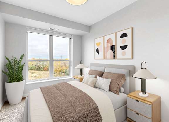 A bedroom with a large bed, a potted plant, and a lamp.