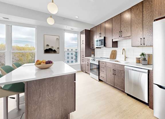 A modern kitchen with a large island and stainless steel appliances.