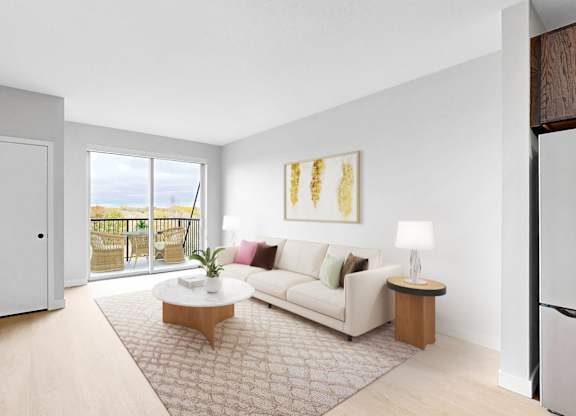 A living room with a white sofa, a wooden coffee table, and a flat-screen TV mounted on the wall.