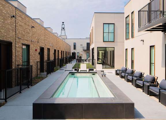 A modern courtyard with a pool and seating area.