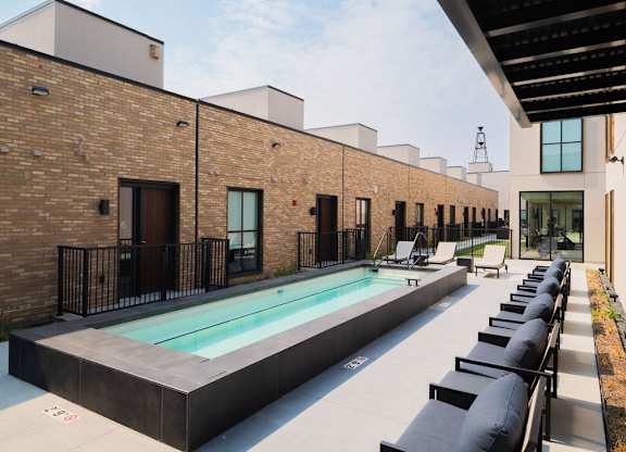 A modern building with a pool in the courtyard.
