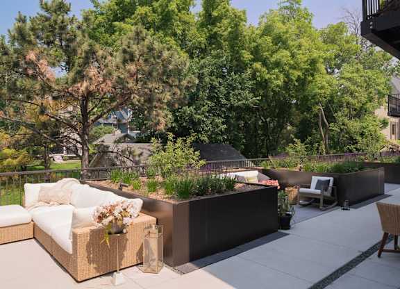 A patio with a white couch and a table with chairs.