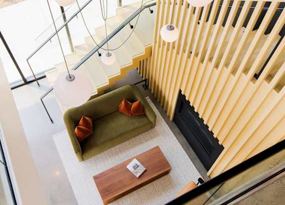 A modern staircase with a glass railing and a wooden handrail.