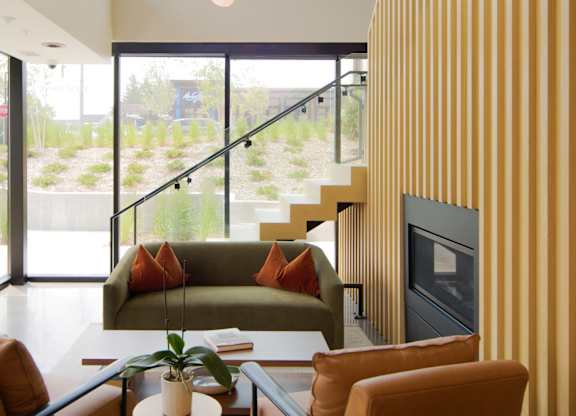 A living room with a couch, chairs, and a fireplace.