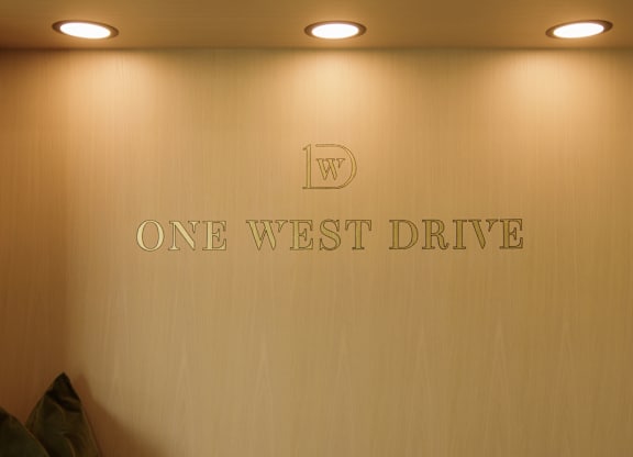 A wall with the words "One West Drive" on it.