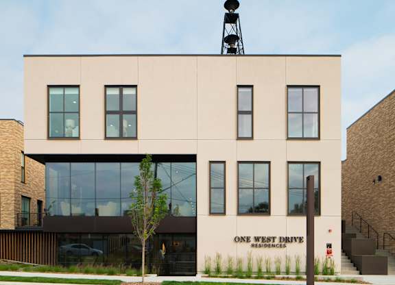 A building with a sign that says "One West Drive Residences" on the side.