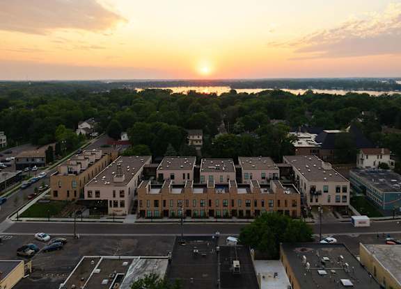 A sunset view of a town with a large building in the foreground.