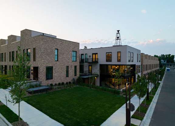 A modern building with a red car parked in front.