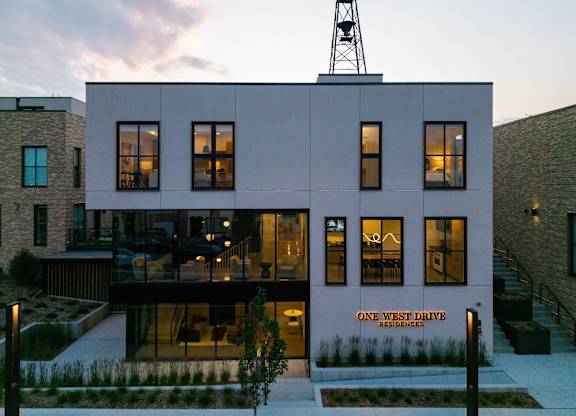 A building with a sign that says "One West Drive Residences" on it.