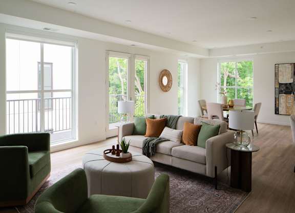 A living room with a green chair and a white couch.