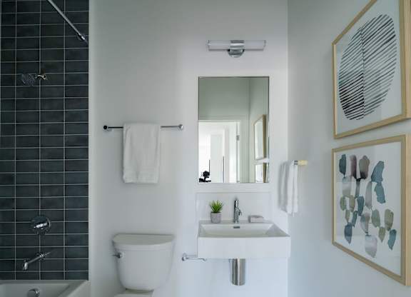 A white toilet sits next to a white sink in a bathroom.