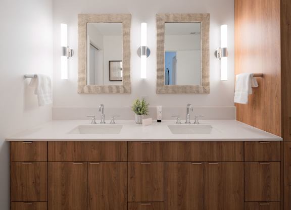 A bathroom with two sinks and two mirrors.
