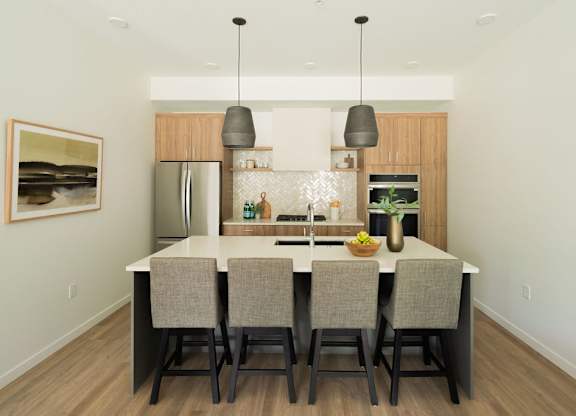 A modern kitchen with a dining table and chairs.