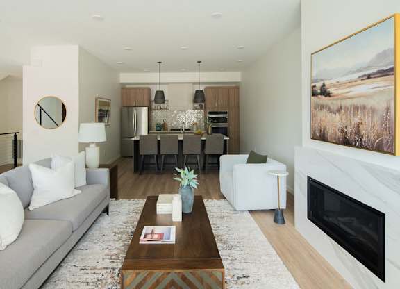 A modern living room with a grey sofa, a coffee table, and a fireplace.