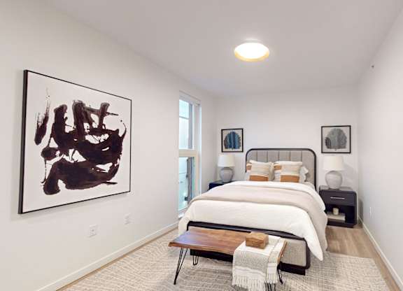 A bedroom with a large bed and a painting on the wall. at One West Drive Apartments, Excelsior, MN 55331