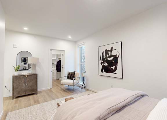 A bedroom with a large bed and a painting on the wall at One West Drive Apartments, Excelsior, Minnesota