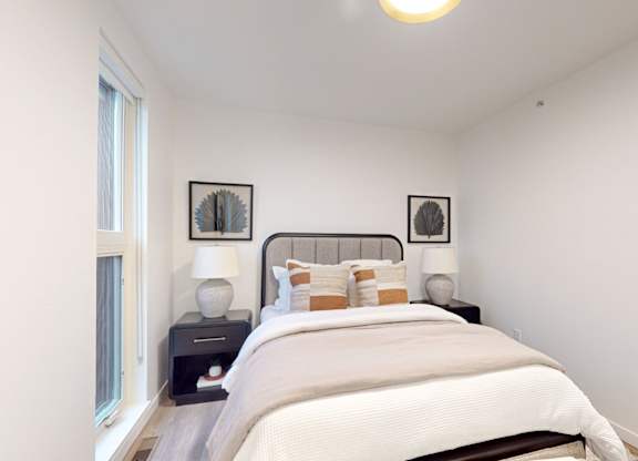 Bedroom with a large bed and two pictures on the wall at One West Drive Apartments, Excelsior, Minnesota