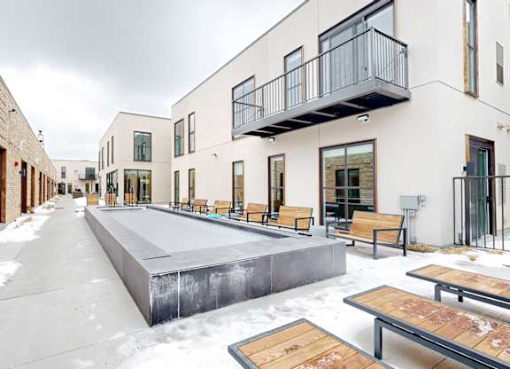 A snow-covered walkway leads to a building with a balcony.