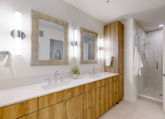 A bathroom with a wooden vanity and a mirror above it.