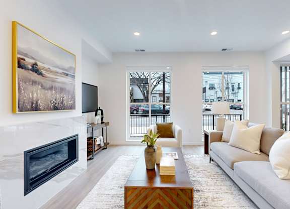 A living room with a fireplace and a painting on the wall.