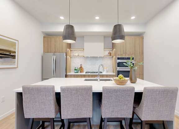 A modern kitchen with a dining table and chairs.