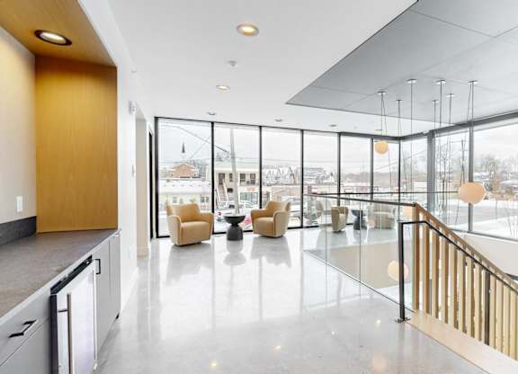 A spacious interior with a kitchen area and a view of the outdoors through large windows.