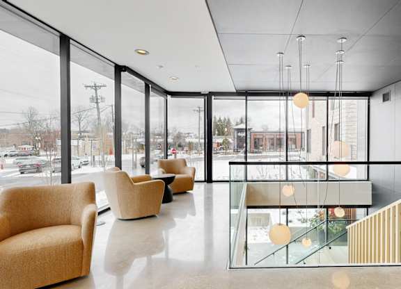A modern interior with a glass wall and a staircase.
