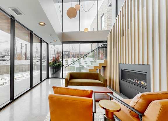 A modern living room with a fireplace and a view of the outdoors.