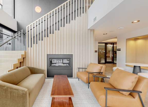 A living room with a tan couch and a wooden coffee table.