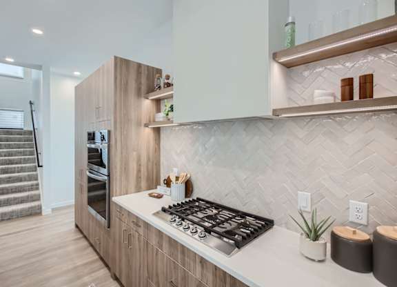 a kitchen with wood cabinets and a stove and a refrigerator at One West Drive Apartments, Excelsior, MN 55331
