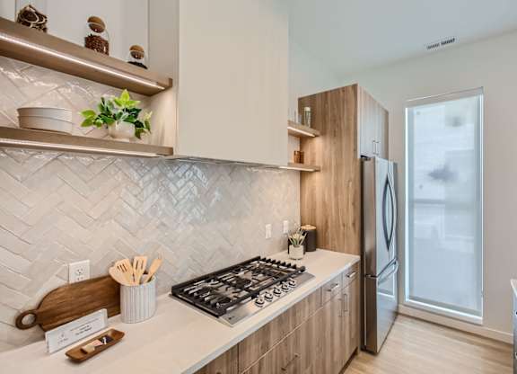 a kitchen with wooden cabinets and a stove and a refrigerator at One West Drive Apartments, Minnesota, 55331