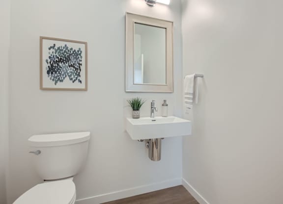 a bathroom with a sink and a toilet and a mirror at One West Drive Apartments, Excelsior