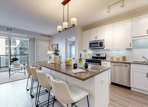 A modern kitchen with white cabinets and a large island.