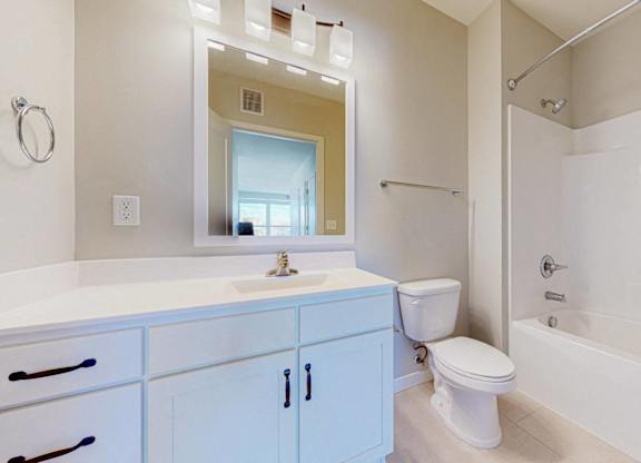 A white bathroom with a blue cabinet.
