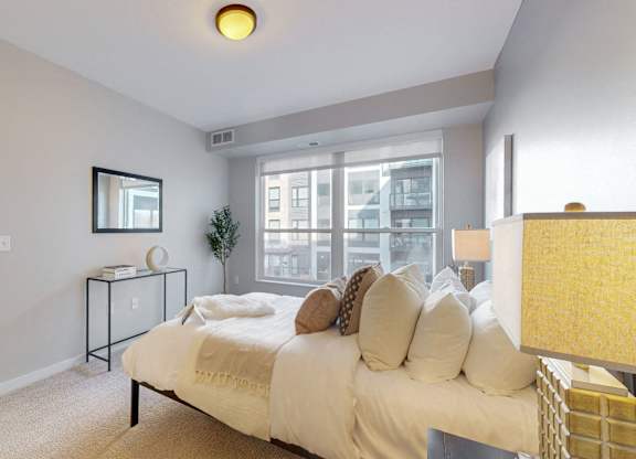 A bedroom with a bed, nightstand, and chair.